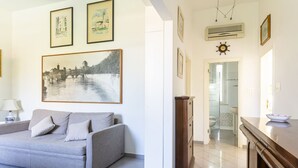 A living room with a sofa, a cabinet, and a painting on the wall.