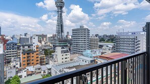 A cityscape with a prominent tower and various buildings, including a hotel with signage. - Apartment Hotel 11 Tsutenkaku (Osaka)