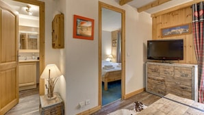 A cozy room with a wooden bed, a television, and a rustic dresser.