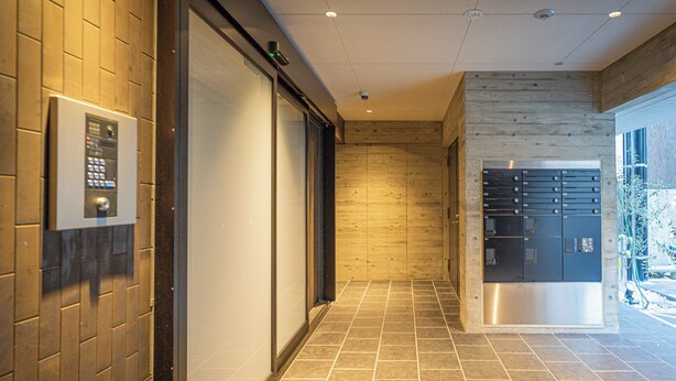 A hallway with a sliding door, a security keypad, and a metal locker area. - Apartment Hotel 11 Umeda Kamiyama (Osaka)