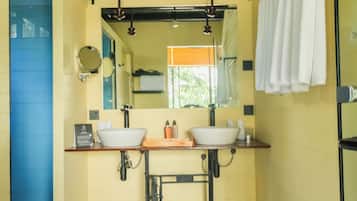A bathroom with two sinks, a mirror, and a towel rack.