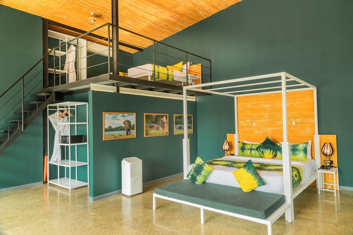 Une chambre moderne avec un lit à baldaquin, un lit superposé au-dessus, un escalier et une petite étagère blanche.