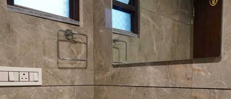 A bathroom with a white sink, a mirror, and a towel rack.