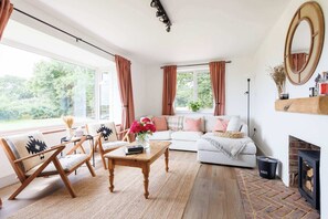 A cozy living room with a sofa, chairs, a coffee table, and a fireplace.