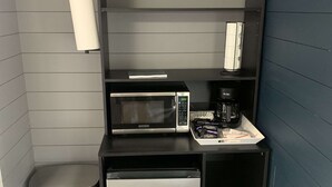 A compact kitchenette with a microwave, coffee maker, and a small trash bin. - TeePee Room 4 - Newly Renovated (Roscommon)