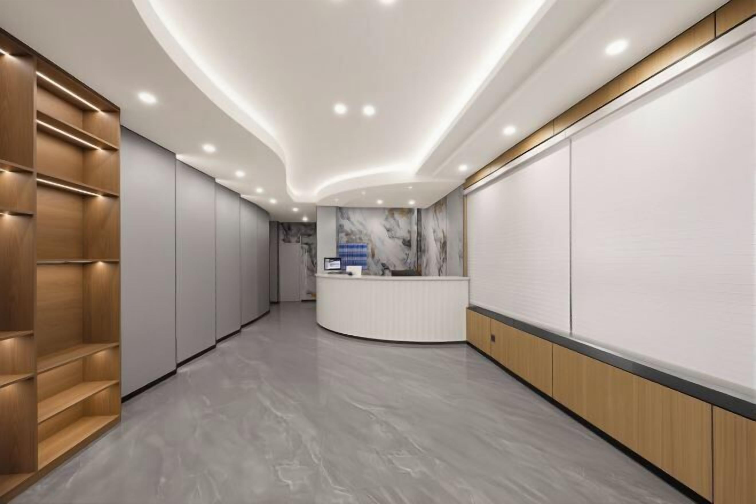 A modern hotel lobby with a reception desk, wooden shelving, and a marble wall.