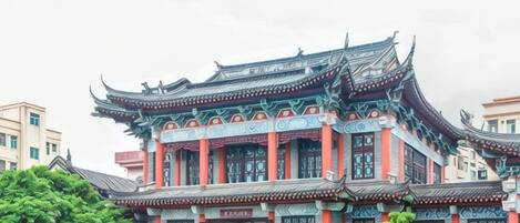 A traditional building with ornate architecture, multiple levels, and a prominent entrance.