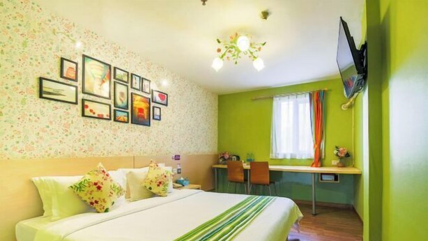 Une chambre d’hôtel avec un lit, un bureau et une télévision.