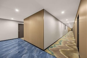 A hotel corridor with a carpeted floor, a wooden partition wall, and a door at the end. - Meiyue Hotel (Shenzhen International Convention and Exhibition Center Shangnan Branch) (Shenzhen)