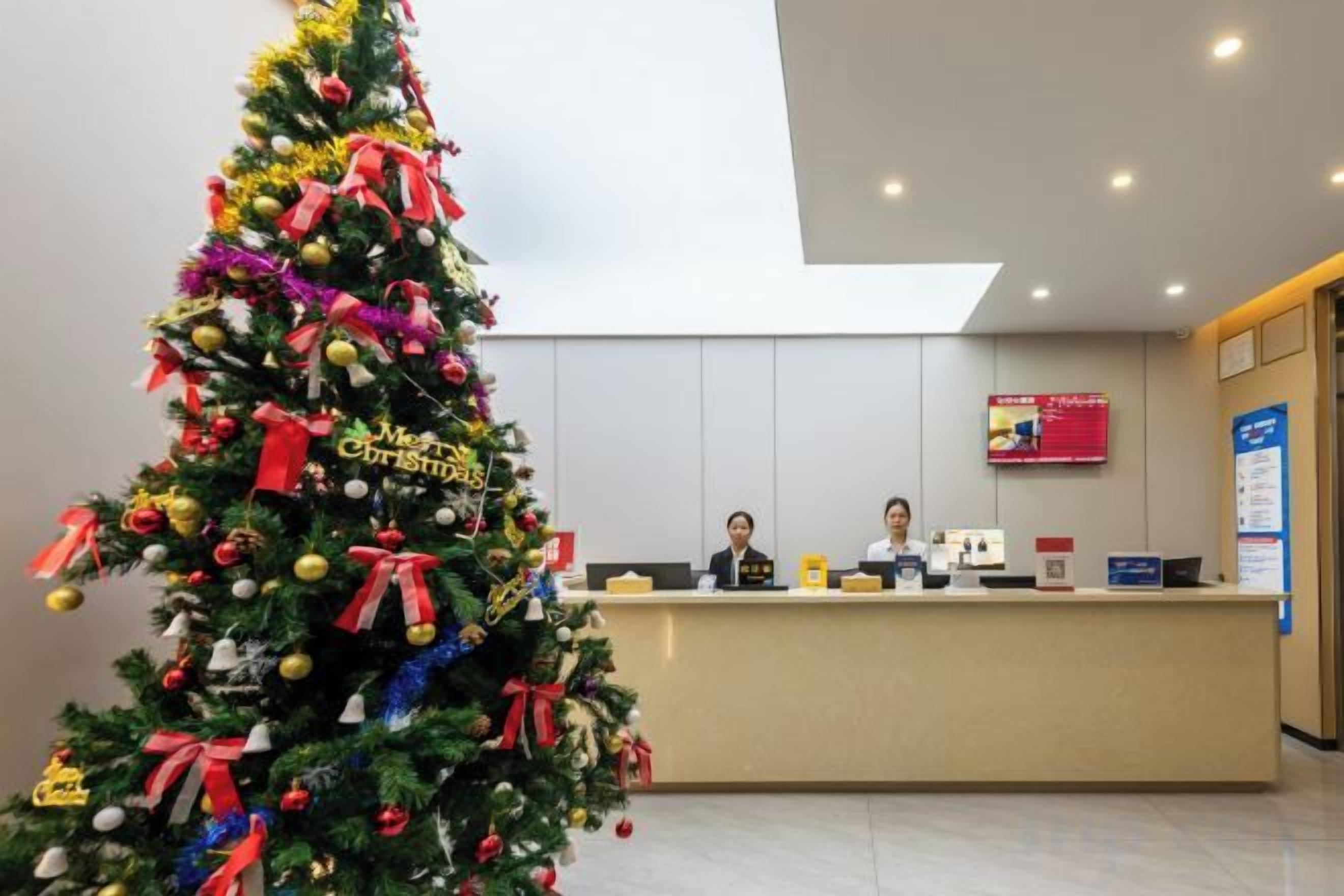 A reception desk with a Christmas tree in the foreground.