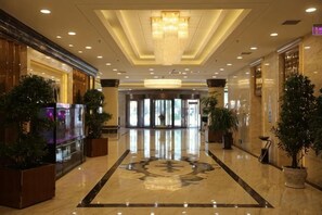 A hotel lobby with a marble floor, a chandelier, and potted plants. - Wenzhou Hotel (Hotan City)