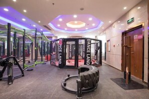 A gym area with weightlifting equipment, a boxing ring, and a tire exercise station. - Wenzhou Hotel (Hotan City)