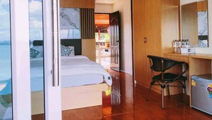 Une chambre d’hôtel moderne équipée d’un lit, d’un bureau, d’une chaise et d’un mini-bar.