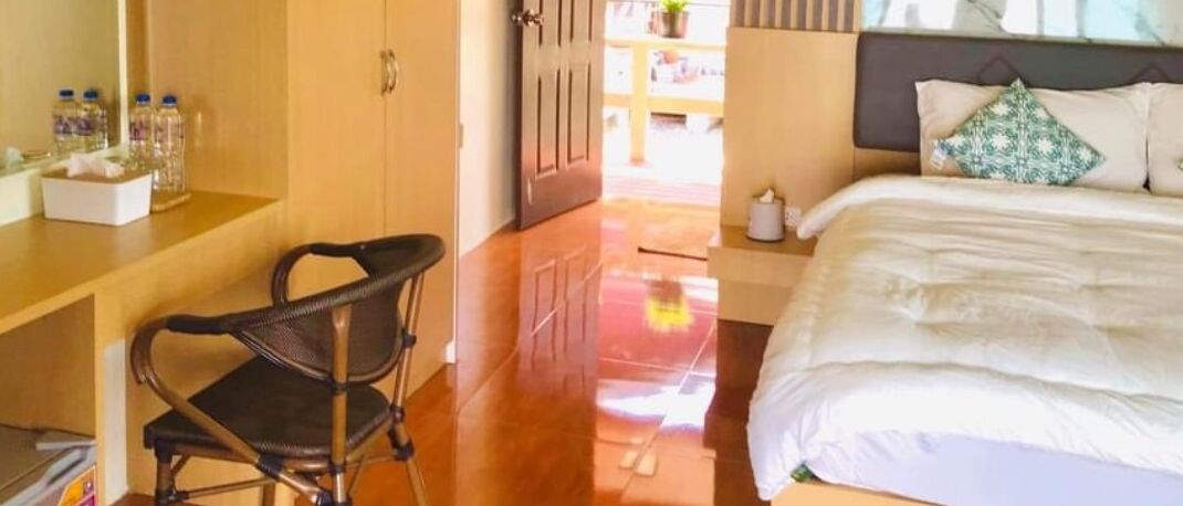 A hotel room with a bed, a desk, and a chair.