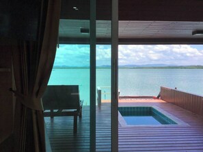 A room with a view of a large body of water, a wooden deck, and a small pool. - Aowlay homestay (Satun)