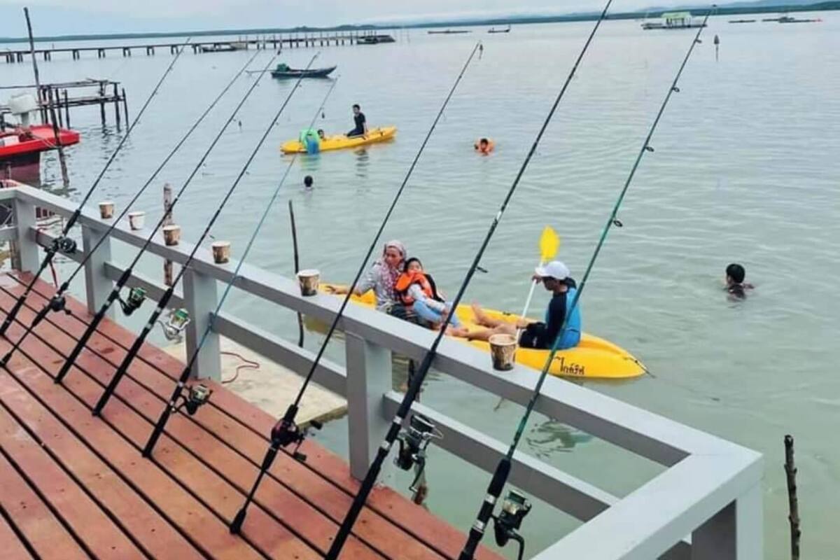A wooden pier with fishing rods and a yellow kayak.