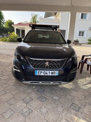 A black Peugeot car parked on a paved surface.