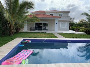 A modern house with a swimming pool, surrounded by a well-maintained lawn and palm trees. - Villa Moderne de 2000m2 Avec Grande Piscine Chauffée Sécurisée Pour les Enfants (Saly)