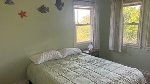 A bedroom with a bed, two windows with curtains, and wall decorations including fish and a star. - Beautiful 4 bedroom 3.5 bath Home 5 minutes from Down Town Austin. (Austin)