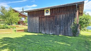 A rustic wooden barn with a target on the side, surrounded by a well-maintained lawn. - Apartment 'Ferienwohnung in Altem Bauernhaus' with Mountain View, Private Garden and Wi-Fi (Schwarzenberg)