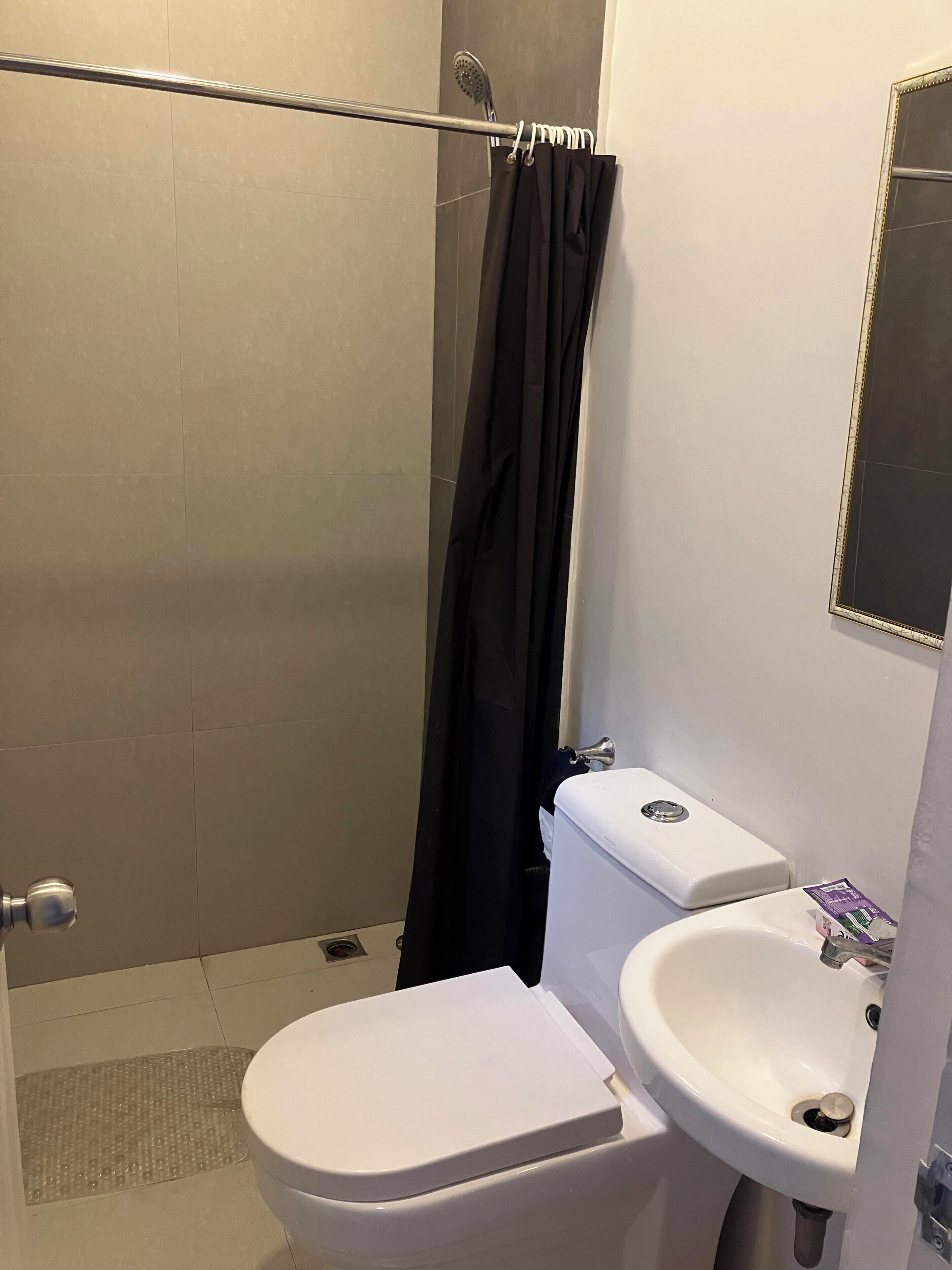 Un baño con ducha, inodoro y lavabo.