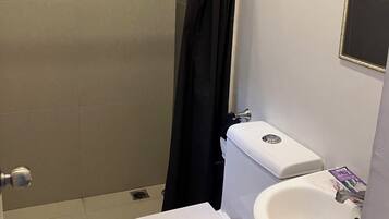 Un baño con ducha, inodoro y lavabo.