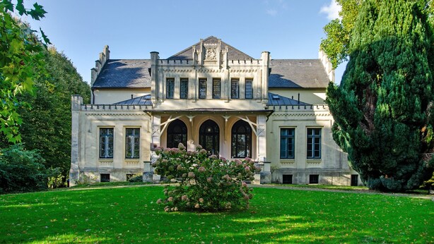 A large, stately building with a symmetrical facade, arched windows, and a central entrance. - Apartment Möwe with Private Terrace, Fenced Garden & Wi-Fi (Hinte)