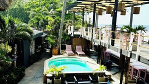 A pool area with lounge chairs and a pergola.