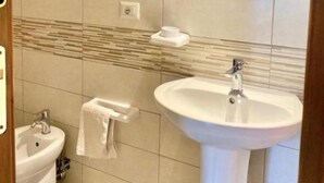 Een badkamer met een wastafel, een wastafelmeubel en een spiegel.