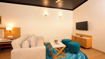 Una sala de estar moderna con un sofá, una mesa de centro, un televisor y un ventilador de techo.