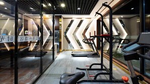 A modern gym with cardio equipment, mirrored walls, and a chevron-patterned wall design. - Nostalgia Hotel（Beijing Jinsong） (Beijing)