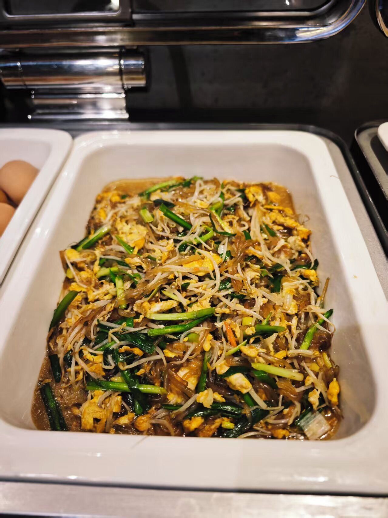 Eine Schale Pad Thai mit Sojasprossen und grünen Zwiebeln.