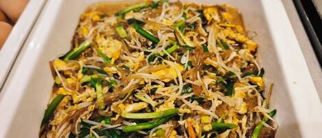 A tray of Pad Thai with bean sprouts and green onions.