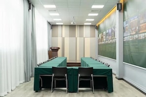 Meetings take place in this well-equipped conference room with a long table and large screen.