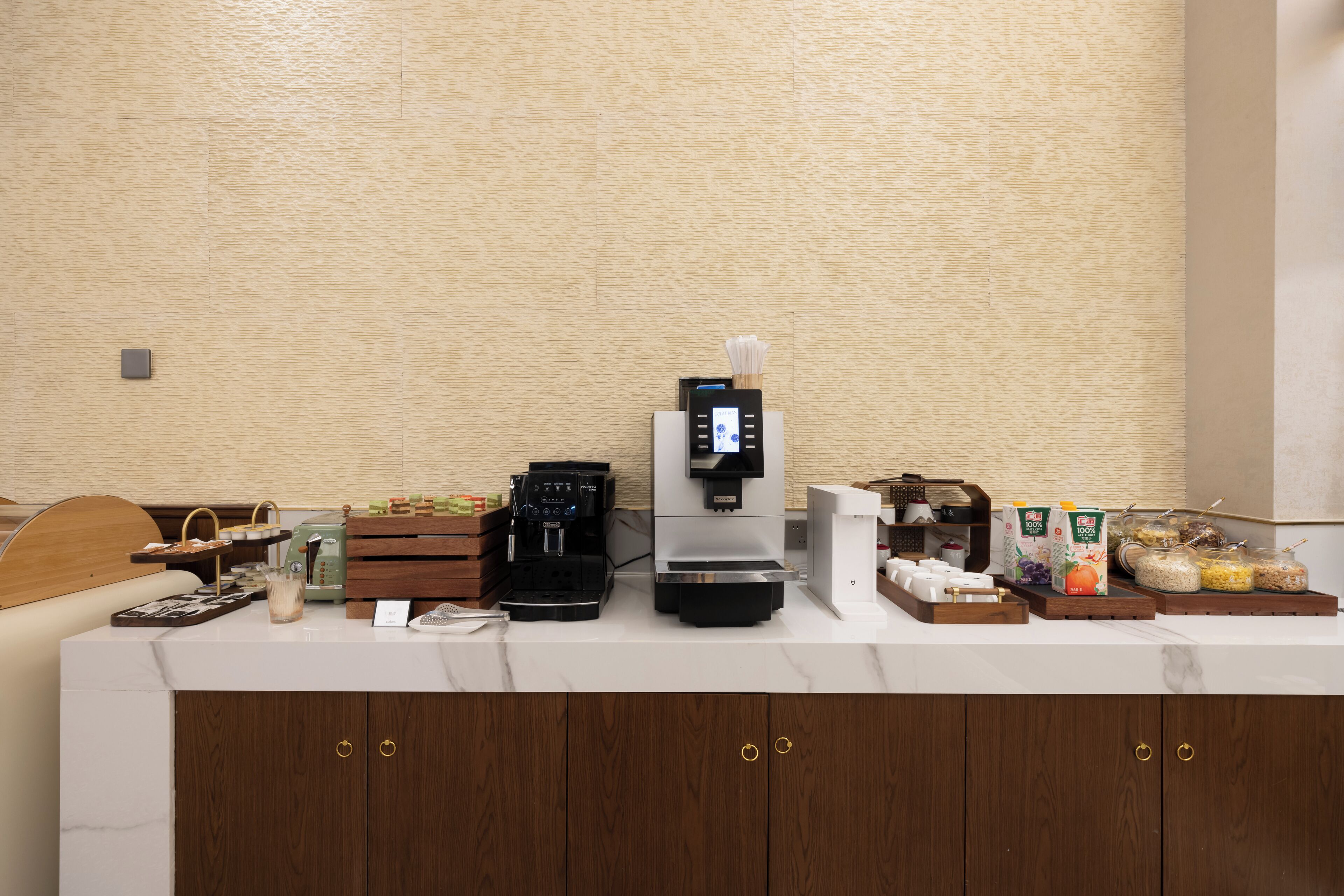 A hotel reception area with a coffee machine, a scale, a cash register, and various food items on the counter.