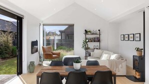 Un intérieur moderne comprenant un coin repas, un canapé et une bibliothèque.