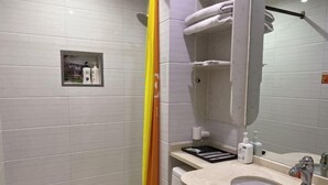 A modern bathroom with a shower, a sink, and a mirror. There are toiletries on the sink and a towel rack above the mirror. - HongxingyangExpressHotel (Wuxiang)