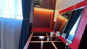 A bathroom with a wooden vanity, a mirror, a sink, and a plant. - HongxingyangExpressHotel (Wuxiang)