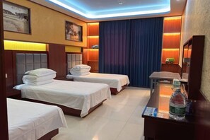 A hotel room with two beds, a desk, a mirror, and a small shelf with a toy car. - HongxingyangExpressHotel (Wuxiang)