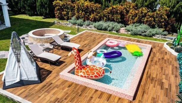 A pool area with a wooden deck, lounge chairs, and a small inflatable pool with various toys. - Cloud Florence Homestay (Hualien)