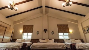 A large room with three beds aligned in the center, wooden beams on the ceiling, and wall-mounted light fixtures. - Cloud Florence Homestay (Hualien)