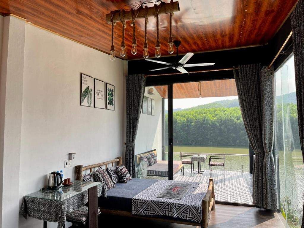 Een slaapkamer met een bed, een tafel en uitzicht op een meer.