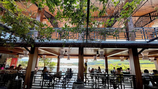 Un restaurant en plein air offrant une vue sur un lac et des collines.