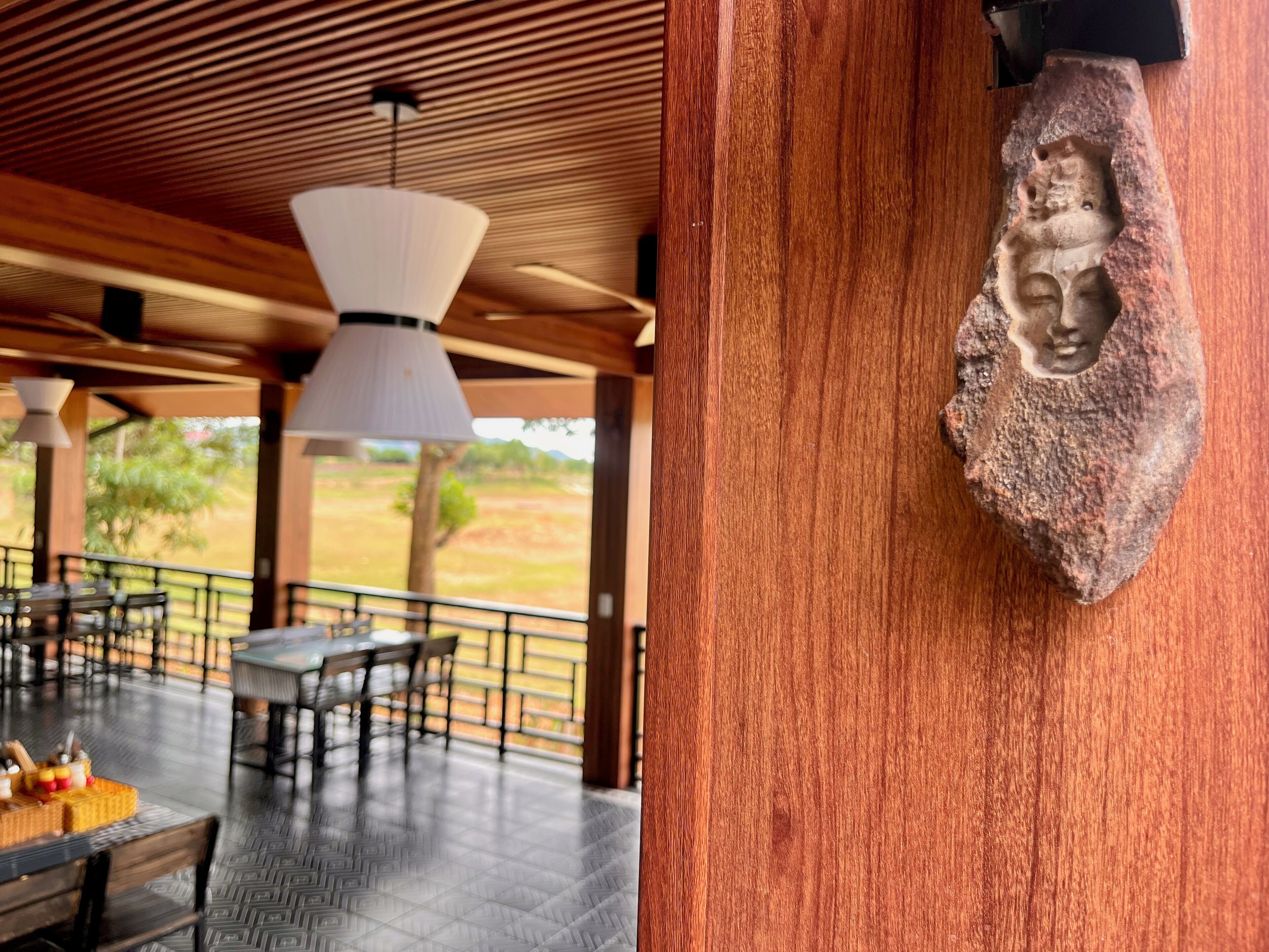 Ein Restaurant mit Außenbereich, Holzbalkendecke und einer Steinsteinarbeit an der Wand.