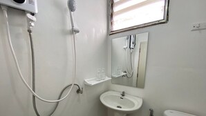 A small, clean bathroom with a pedestal sink, a toilet, and a shower. - cumpun hostel (Chiang Mai)