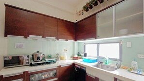 Una cucina compatta con mobili in legno, forno integrato, lavello e finestra.