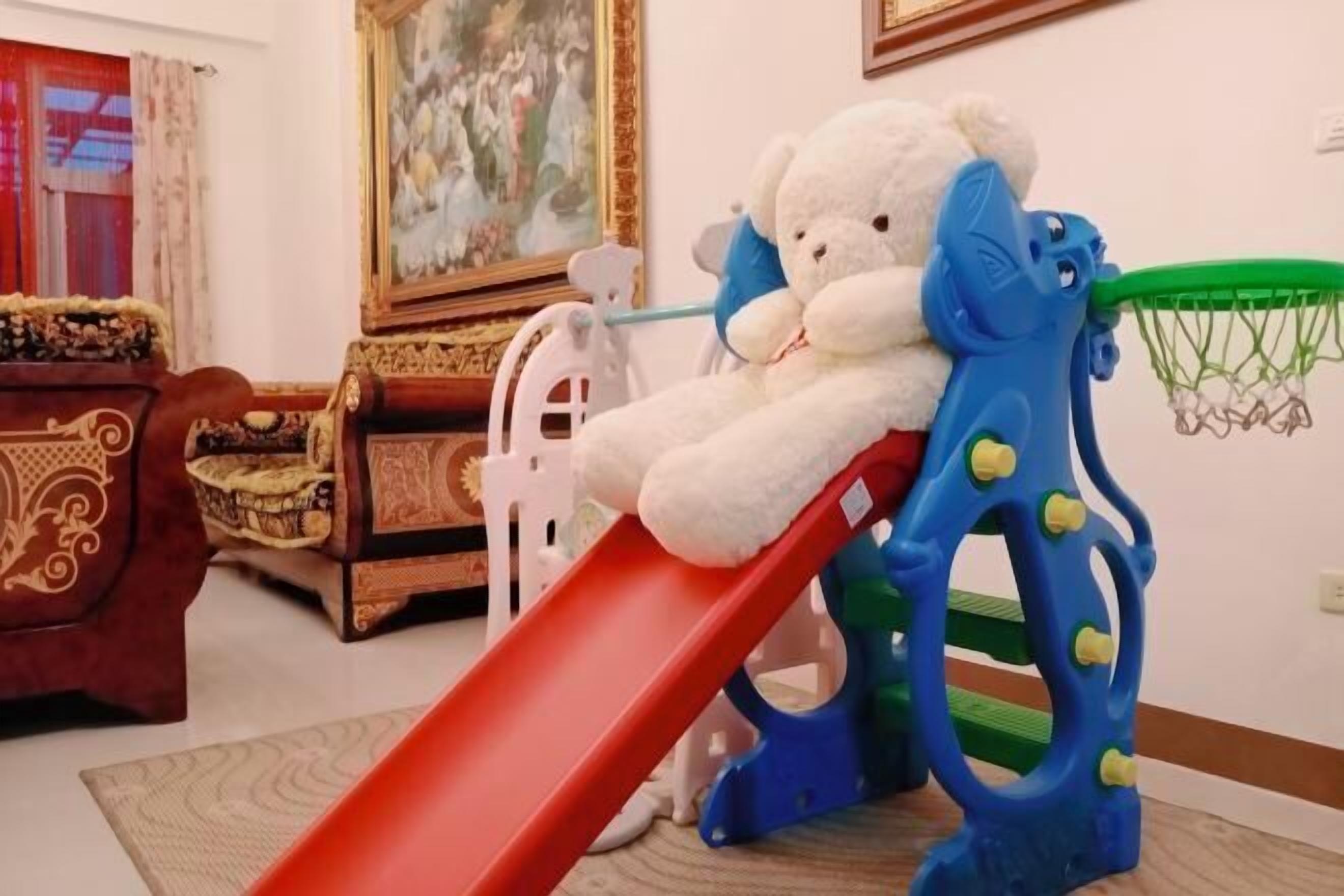 A play area with a red slide and a blue climbing structure.