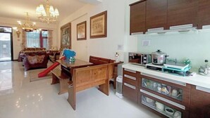 Una cucina moderna con mobili in legno, una zona pranzo con uno scivolo rosso e un lampadario.