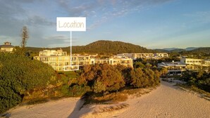 A coastal hotel with a sandy beach, multiple buildings, and a hilly backdrop. - Slice Of Paradise - Direct Resort & Beach Access Apart - 3 Bed - Ocean Views (Cabarita Beach)