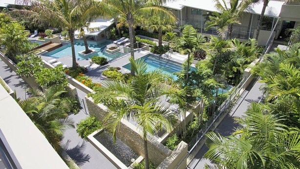A rooftop pool area with multiple swimming pools, surrounded by palm trees and greenery. - Slice Of Paradise - Direct Resort & Beach Access Apart - 3 Bed - Ocean Views (Cabarita Beach)